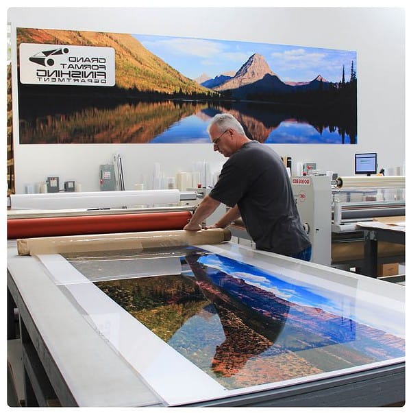 a man is working on a large painting.